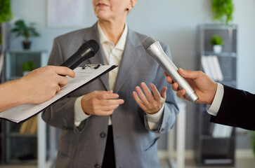 Crop middle aged woman official authority representative in formal suit answers questions of...