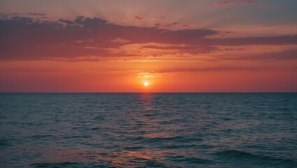 Obraz premium Sunset over the ocean with vibrant sky colors and calm waters.