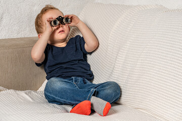 Toddler with tiny binoculars exploring his living room.
Amazed kid discovering his world more...