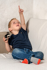 Toddler with tiny binoculars exploring his living room.
Amazed kid discovering his world more closely.