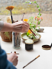 Florist arranging flowers and painting kenzan for ikebana flower arrangement