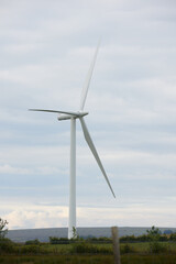 Singular wind turbine past the brow of a hill