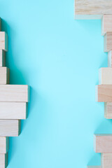 This minimalist composition features wooden blocks forming a frame on a serene blue background. It...