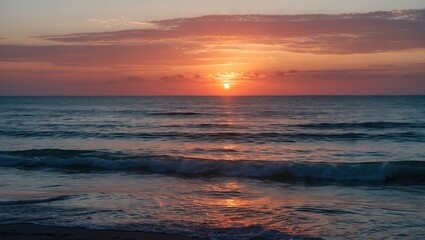 Obraz premium Sunset over the ocean with the sun near the horizon and waves in the foreground. Natural scenery at dusk.