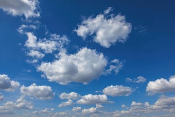 Fototapeta premium Clouds scattered across a blue sky with varying sizes and densities