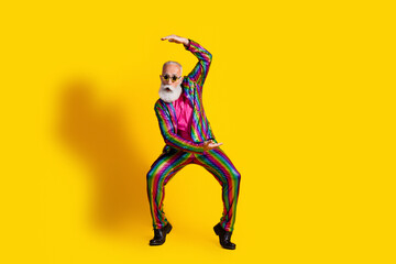 Charismatic elderly man in colorful disco attire striking a playful pose against a vibrant yellow...