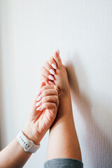 Hands engaged in a relaxing stretch against a smooth white wall in a calm setting