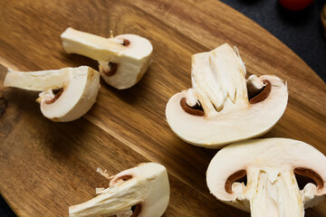 Freshly sliced mushrooms on a wooden cutting board ready for cooking