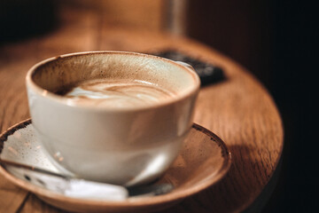 close up coffee cup on the left that has had a sip taken out of it
