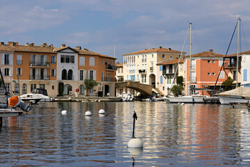 Port Grimaud harbor from the water with ships, yachts, pier and shops as well as residential...