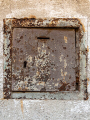 Old rusty alms box on wall with peeling plaster, copy space