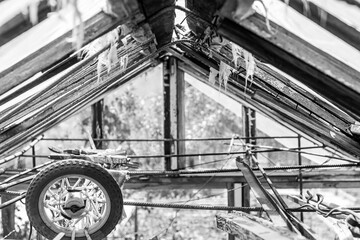 A decaying greenhouse interior with fractured glass and a colorful wheel, hinting at forgotten...