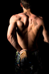 Close-up of a shirtless muscular man rubbing chalk on his hands before training or climbing. The...