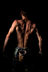 Close-up of a shirtless muscular man rubbing chalk on his hands before training or climbing. The...