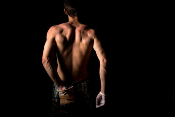 Close-up of a shirtless muscular man rubbing chalk on his hands before training or climbing. The...