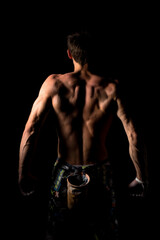 Close-up of a shirtless muscular man rubbing chalk on his hands before training or climbing. The...