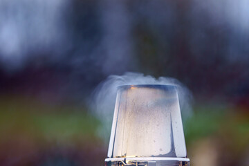 Steam rises from a glass container in an outdoor kitchen as the sun sets on a chilly evening