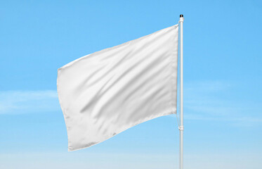 White flag waving against clear blue sky, symbol of peace, freedom, or surrender, ideal for...