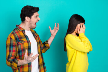 Young couple arguing with vivid expressions against a vibrant turquoise background, dressed in...