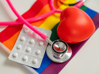Rainbow flag, pills, heart and stethoscope.