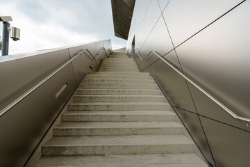 Concrete stairs leading to a modern building entrance during cloudy weather