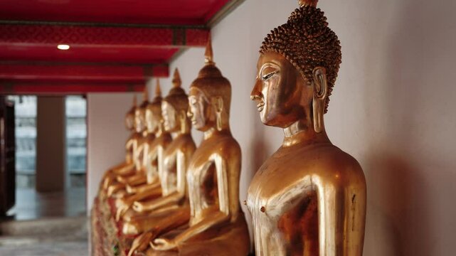 Golden buddha statues inside ornate wat pho temple interior, highlighting sacred spiritual environment of iconic Bangkok buddhist landmark, Thailand.