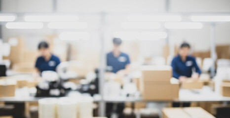 Three women work in a bright factory setting packaging items into boxes.