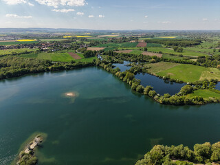 A breathtaking aerial view capturing the serene lake surrounded by beautiful lush greenery Koldinger Seen Hannover Pattensen