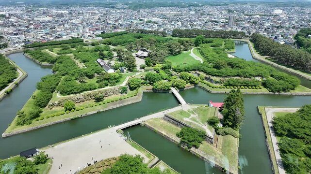 A breathtaking aerial view showcasing a historical fortification surrounded by vibrant greenery and water. This image captures the beauty of nature and architectural design, inviting exploration and c