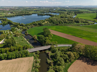 An aerial view showcasing a beautiful, scenic river gracefully winding through lush, green fields...