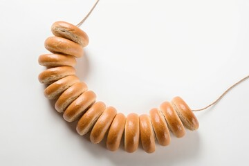 Suszki bagels hanging on a string against white backdrop