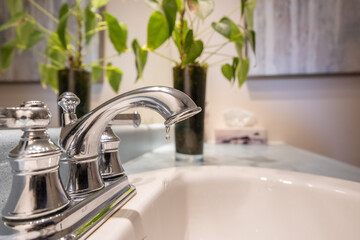 A bathroom faucet slowly dripping water, highlighting a common plumbing issue and water waste