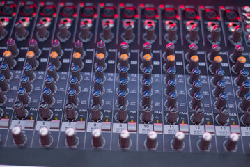 Close-Up of Professional Audio Mixer Console with Colorful Knobs