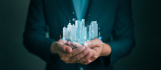 Businessman holding virtual real Estate showing Investment and Market Growth Concept or Analyzes real estate market development growth trends . Real estate and Property insurance and security concept.