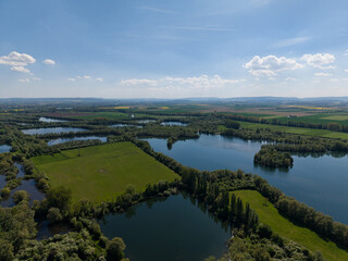 A breathtaking aerial view showcases serene lakes and vibrant lush green landscapes all around...