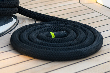 Mooring line coiled on deck on superyacht. Mooring gear on yacht. Superyacht equipment. 