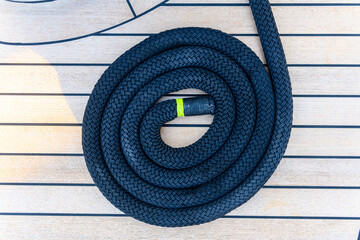 Mooring line coiled on deck on superyacht. Mooring gear on yacht. Superyacht equipment.