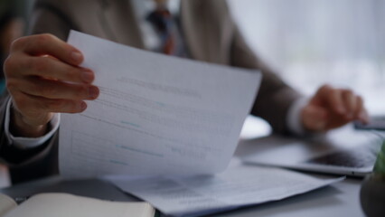 Hands typing computer keyboard at office closeup. Smiling lawyer looking papers