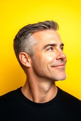 Fototapeta premium Concept graphic pattern of style for aging men. A happy man in a studio photo. Trendy men's classic short back and sides haircut - midlife white man with blond hair. Yellow solid background.