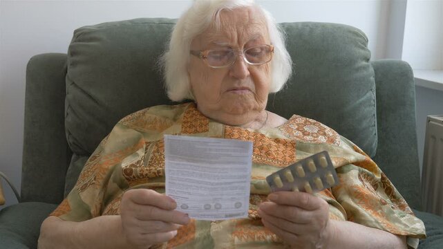 An old woman reads a medicine leaflet