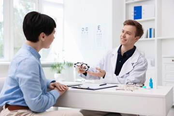 Obraz premium Ophthalmologist consulting woman at table in clinic