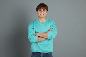 Portrait of teenage boy on grey background