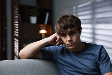 Obraz premium Teen problems. Upset teenage boy on sofa at home