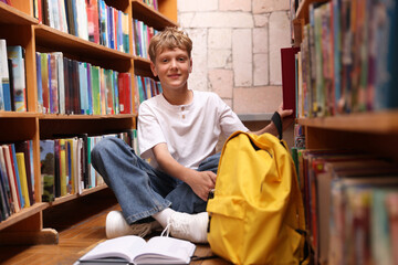 Student taking book out of shelf in library