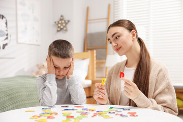 Dyslexia. Mother and her son learning letters at table indoors