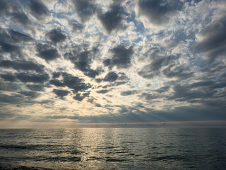 Dramatic sky and sun rays over the sea at sunset