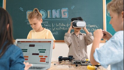 Energetic child wearing Vr headset while enter virtual world at classroom. Student programing...