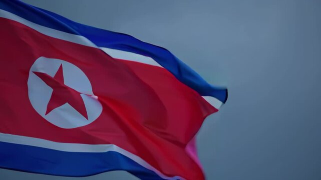 North Korea national flag waving in the wind against a cloudy dramatic sky backdrop