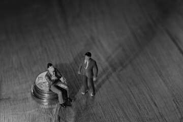 miniaturas plasticas de homen vestindo roupas sociais como executivos, sentado em pilha de...
