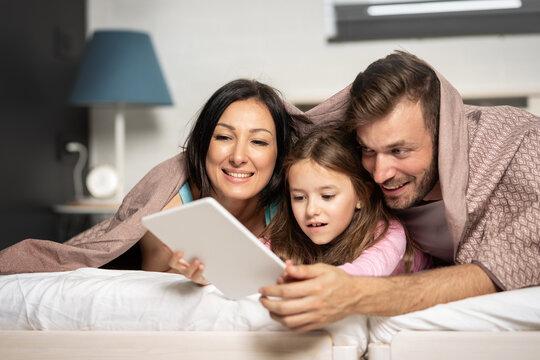 Happy family using tablet together bed images